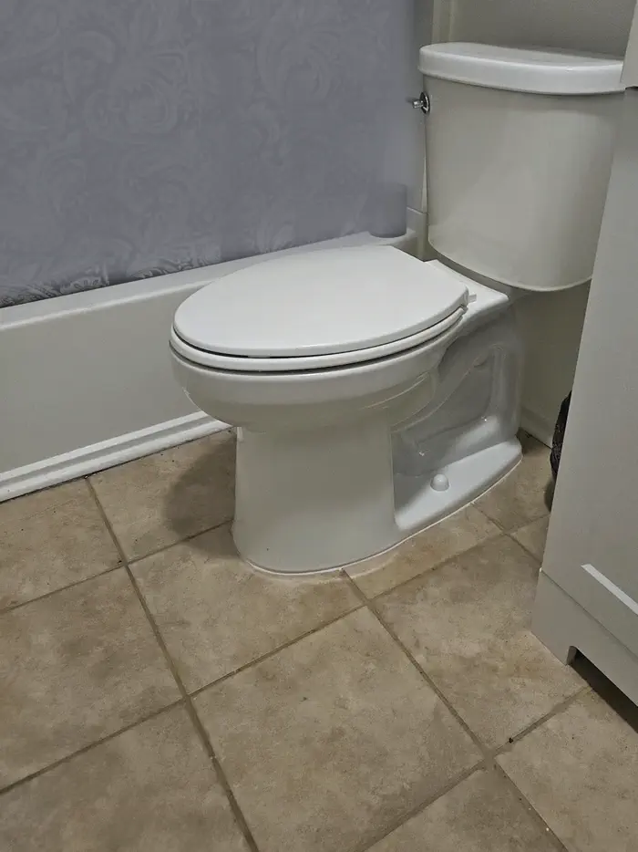 A new white toilet in a tiled bathroom